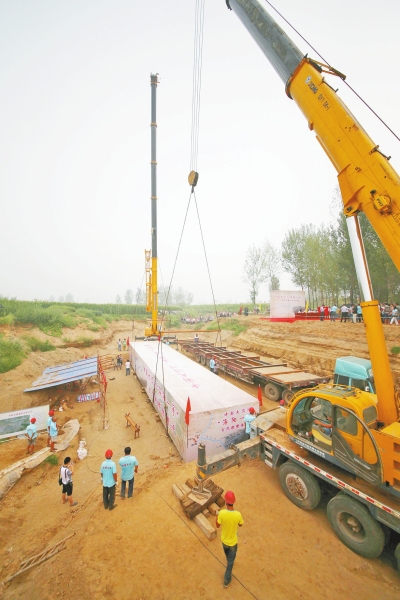 两台吨位级别在70吨的大吊车,将把打包后重达50吨的古船稳稳吊起,放置在一辆载重70吨的半挂牵引车上