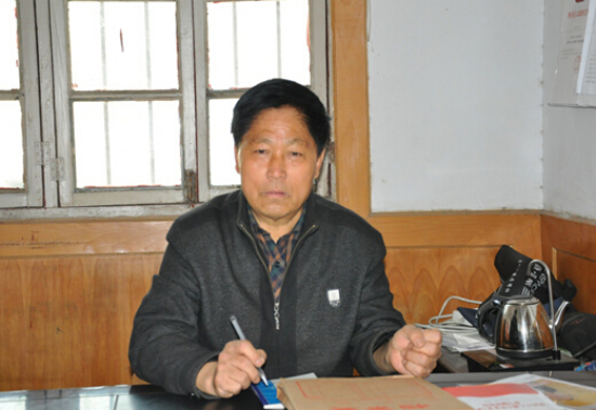 65岁的村支书喻殿英工作中面带倦容