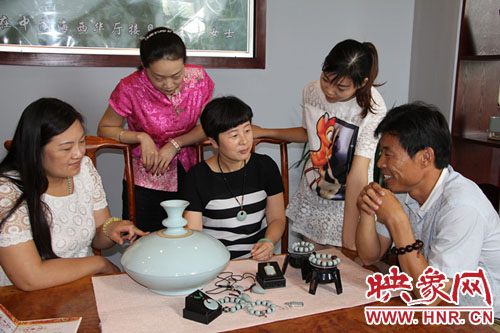 河南省陶瓷艺术大师李晓涓（右三）正在向顾客展示《守静尊》