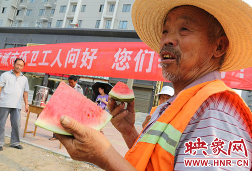 7月28日，环卫工人在平顶山市宝丰县免费茶水点吃西瓜解酷暑。
