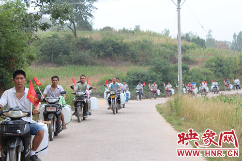 爱心送水队行走在蜿蜒崎岖的山路上