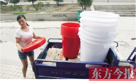 一家超市的工作人员在搬运塑料大桶。