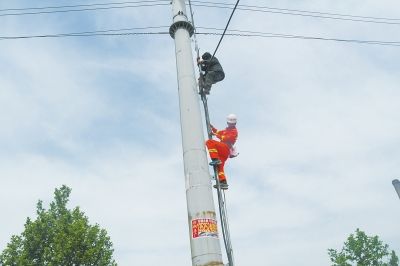 消防队员爬上电线杆救人