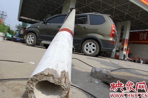 一根线杆从根部折断，压倒在一辆棕色私家车上