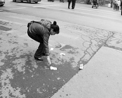 郑州一市民骑车掉落百元大钞 多市民帮捡交民警