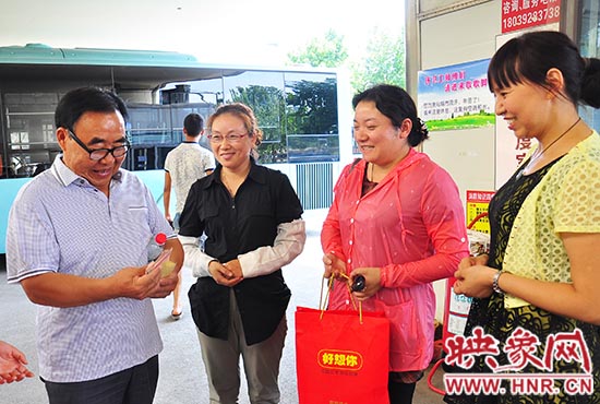 郑州公交四公司二车队副书记李瑶将钱袋子和4000元现金交给徐老汉。