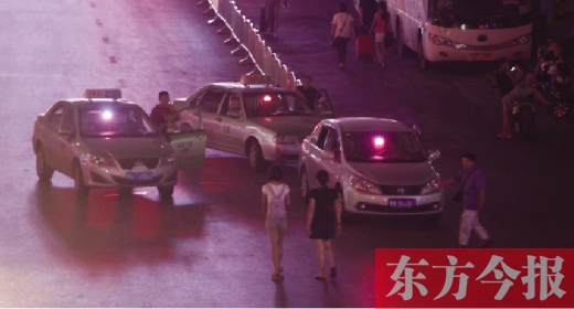 7月23日20时许，郑州火车站、长途汽车客运站出入口，三辆亮着“空车”灯的“出租”停在马路当中等客