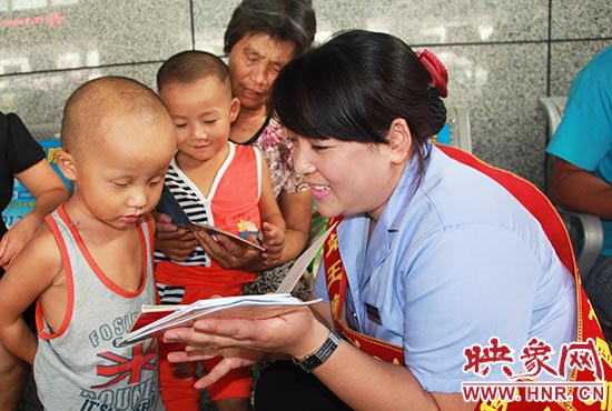 “王静班组”工作人员在教候车的儿童读书。