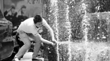 一位市民在新都汇喷泉旁取水降温