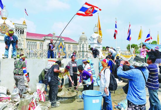 泰国示威者17日在总理府大门外搭建水泥墙，声称要阻止英拉回总理府工作。