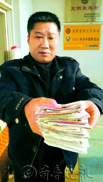 赵庆文手里的单据摞起来有十几厘米。本报记者杜洪雷摄