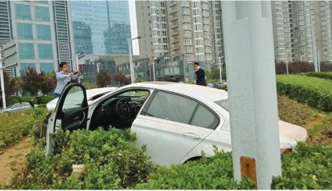 白色轿车冲进了绿化带。