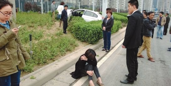 轿车掉了右前轮,撞倒路灯又冲上了绿化带。