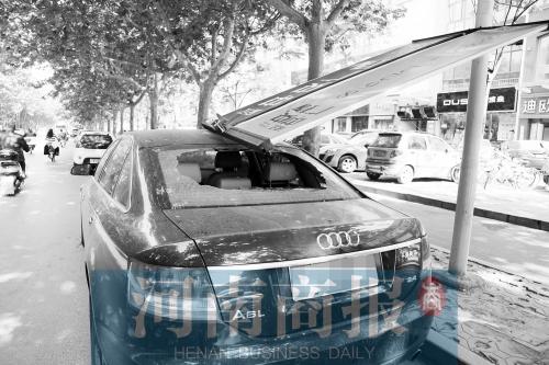 大风刮落路边广告牌 郑州一市民爱车被砸大洞