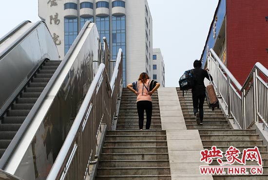背着大小行李的旅客只能一步一步爬楼梯