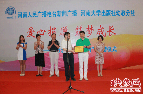 河南电台总编辑张大宝为爱心企业颁发奖牌