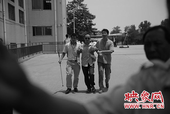 6月7日12时30分,盲人考生李金生走出高考考场。