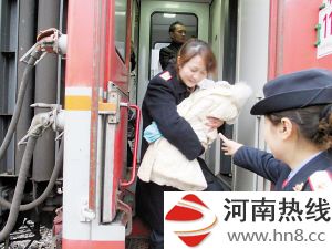 列车员小心翼翼地将孩子抱下车(綦江火车站客运部供图)